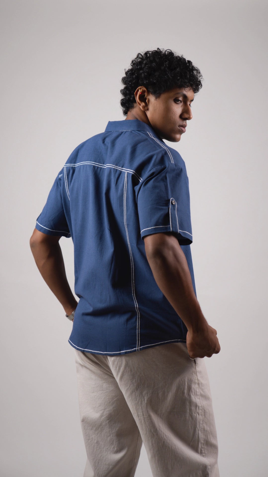 Back view of a man wearing a blue cotton linen half-sleeved shirt