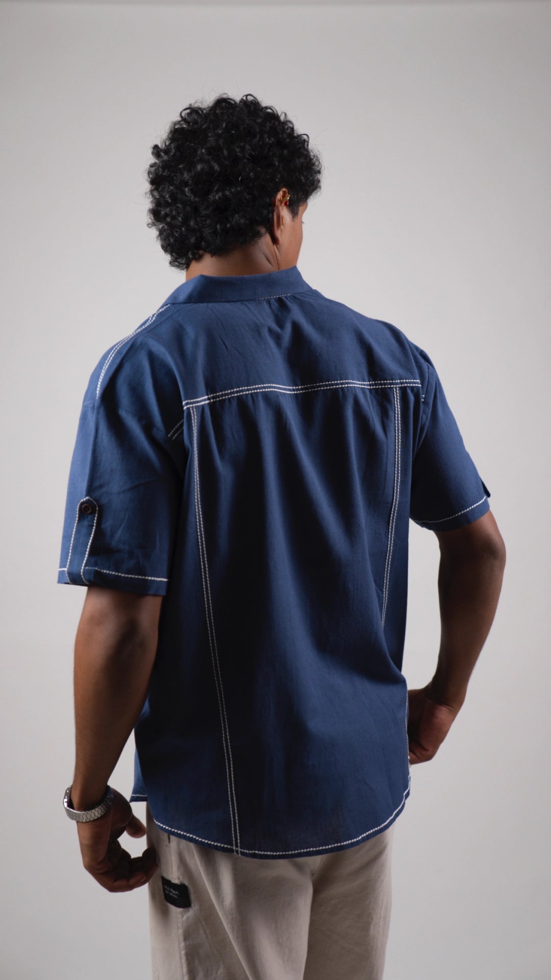 Back view of a man wearing a blue cotton linen half-sleeved shirt