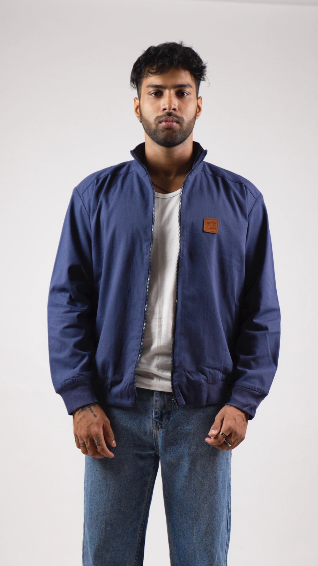 Man wearing a blue jacket with a brand logo on a white background