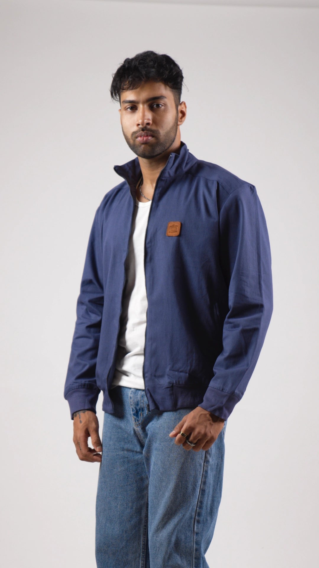 Man wearing a blue jacket with a brand logo on a white background