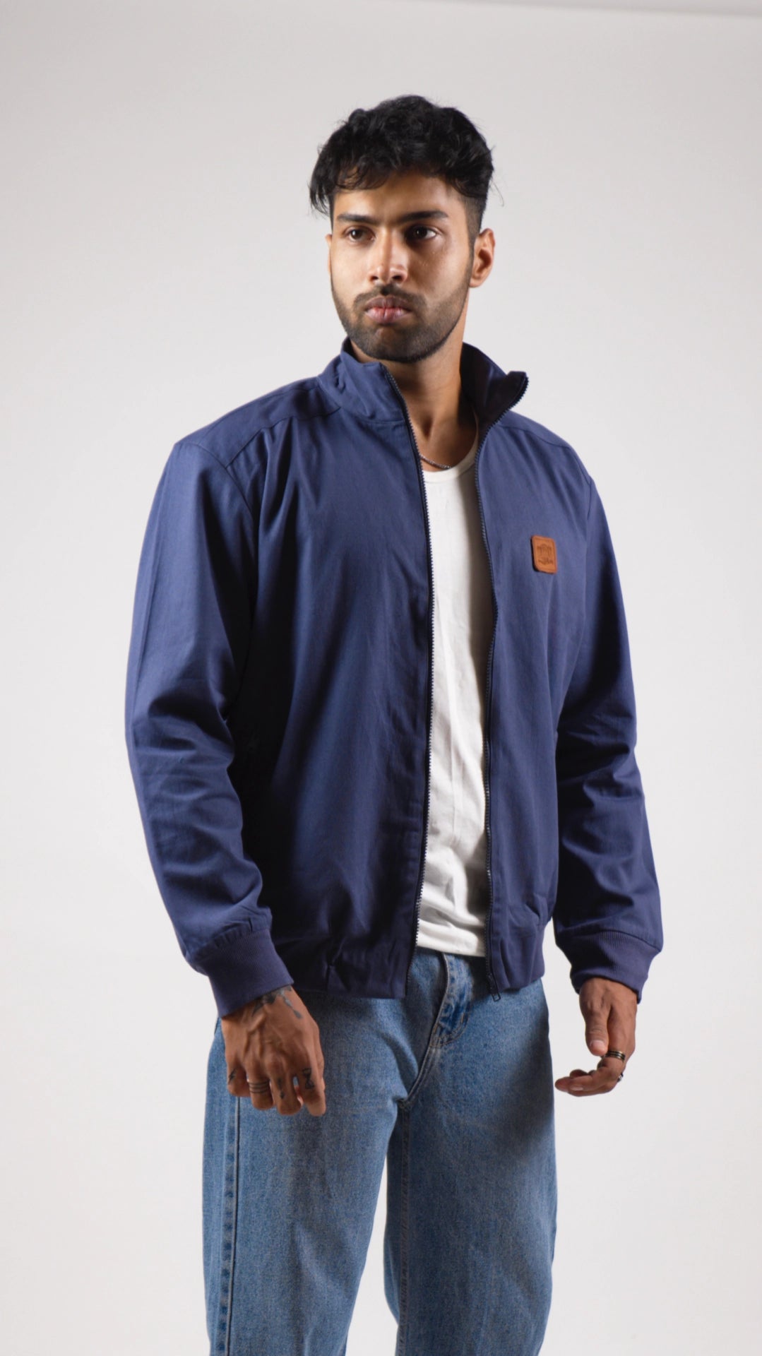 Man wearing a blue jacket with a brand logo on a white background