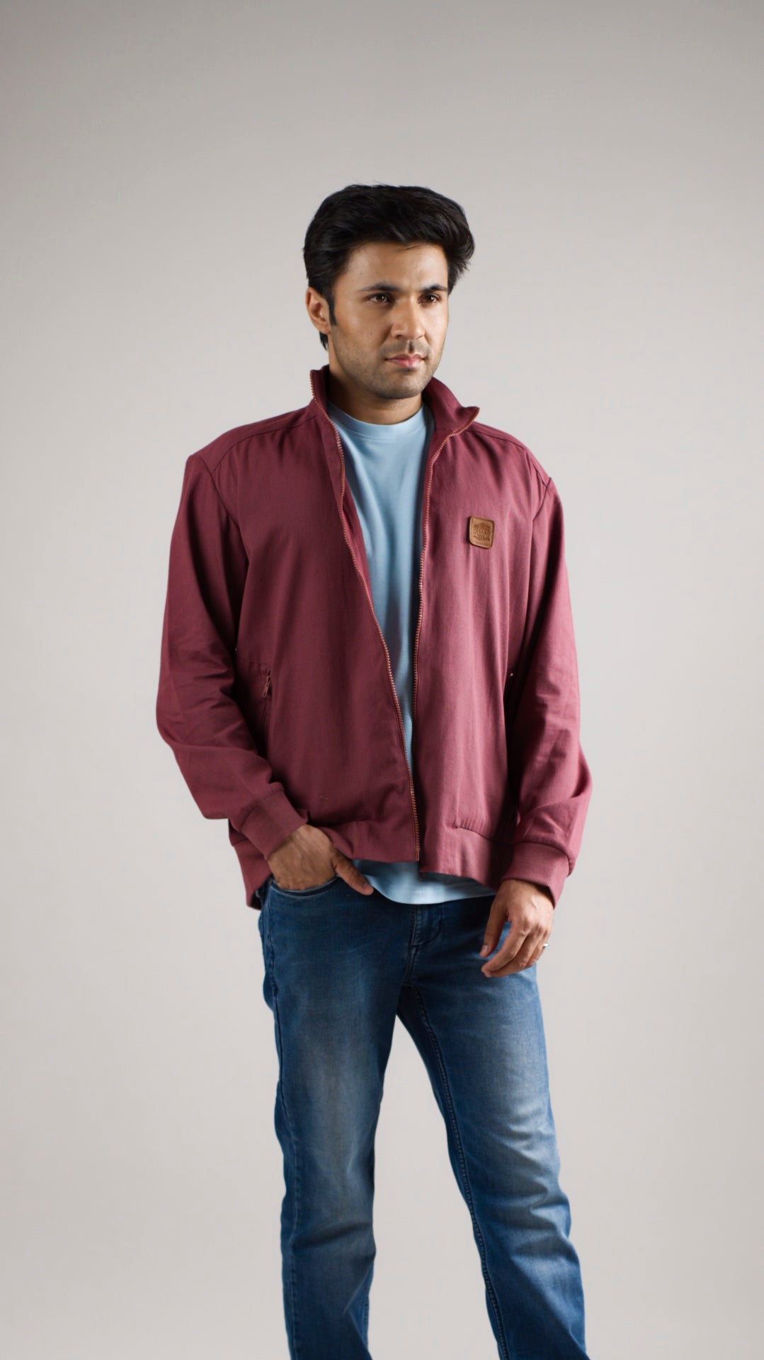 A man wearing a deep garnet-coloured cotton twill jacket