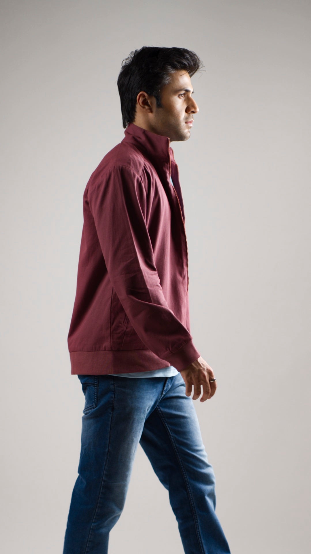 A man wearing a deep garnet-coloured cotton twill jacket