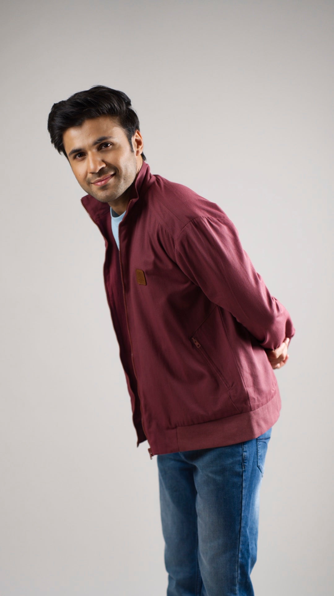 A man wearing a deep garnet-coloured cotton twill jacket
