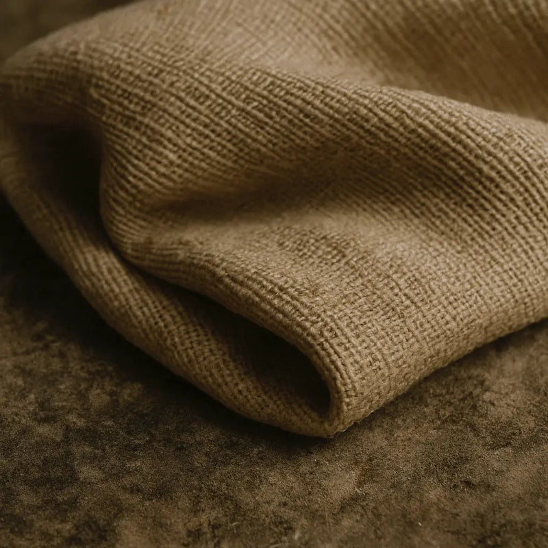 Close-up of beige fabric with a textured pattern on a brown background