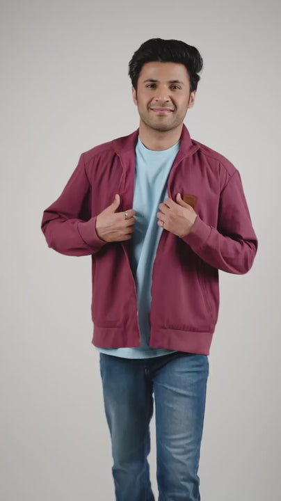 Video of a man wearing a deep garnet-coloured cotton twill jacket on a light shirt and blue jeans