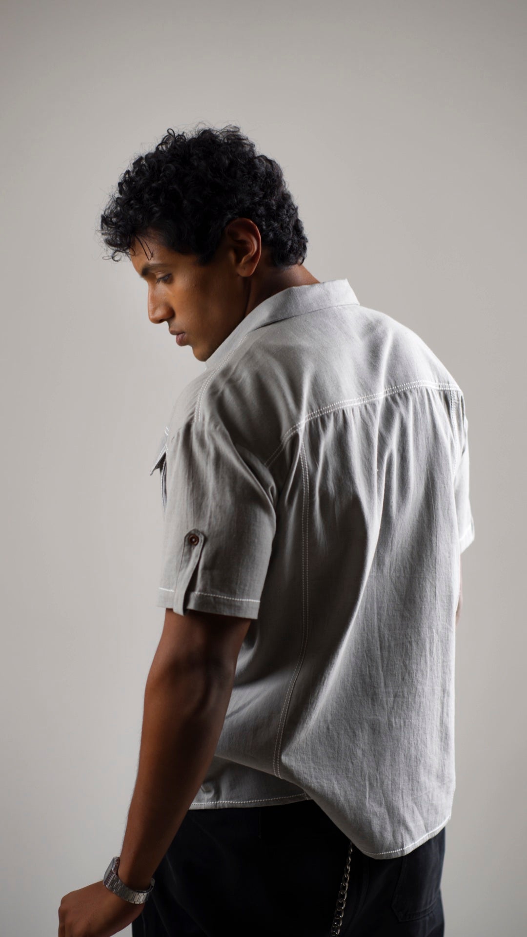 Back view of a man wearing a gray cotton linen half-sleeve shirt