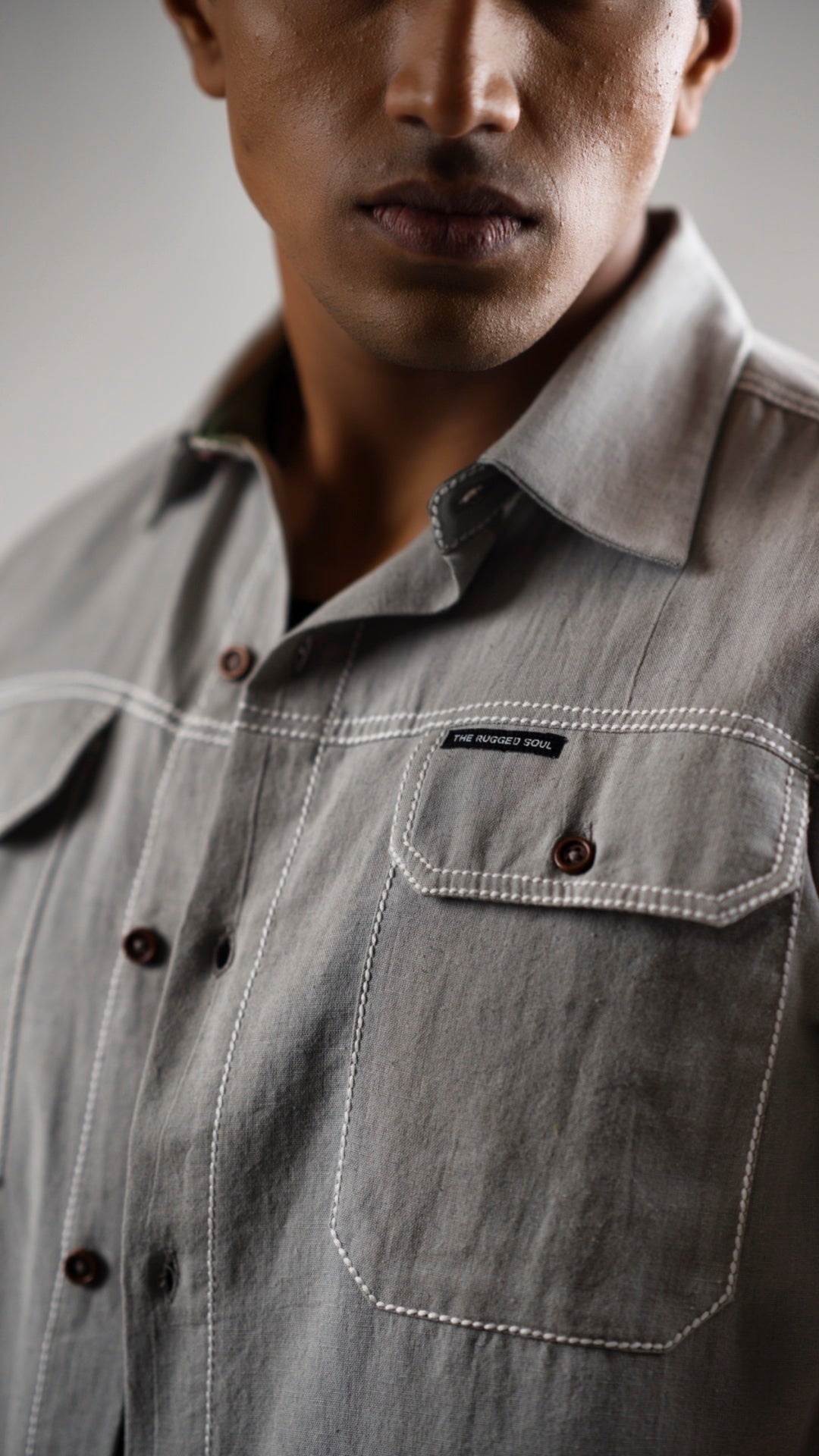 Closeup of a man wearing a gray cotton linen half-sleeve shirt