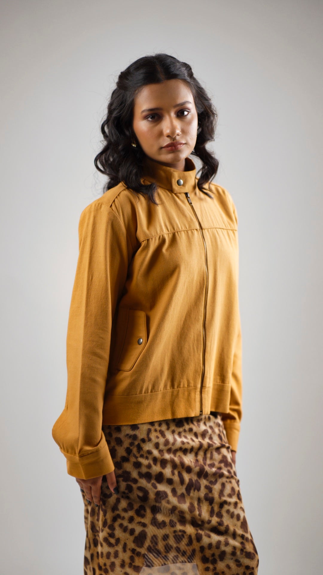 Woman wearing a mustard coloured cotton canvas jacket over a leopard print