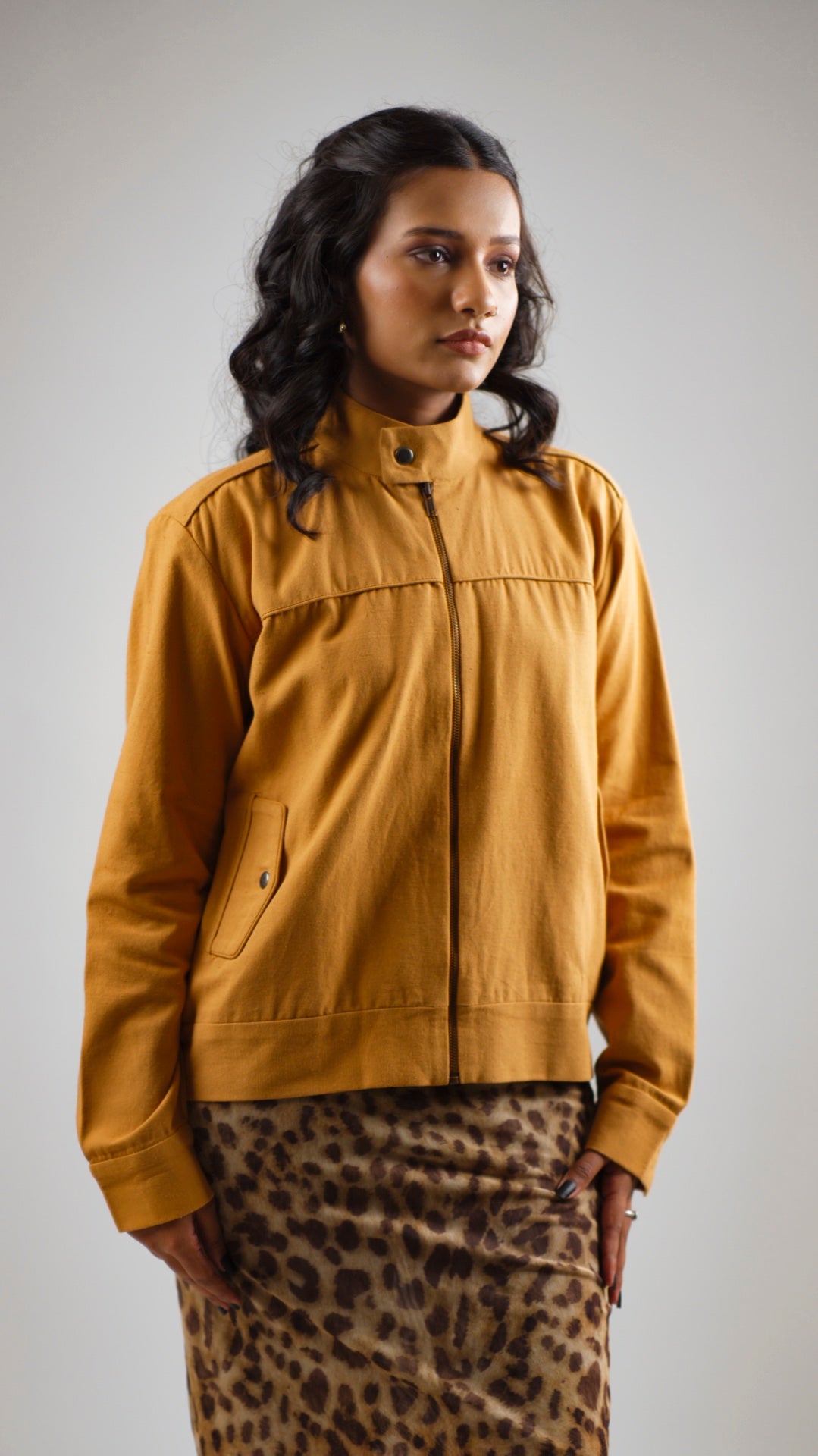 Woman wearing a mustard coloured cotton canvas jacket over a leopard print