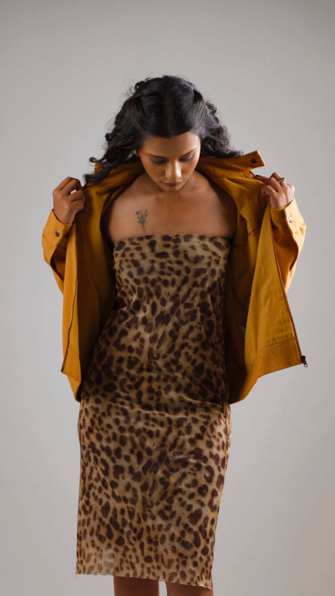 Woman wearing a mustard coloured cotton canvas jacket over a leopard print