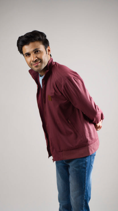 A man wearing a deep garnet-coloured cotton twill jacket
